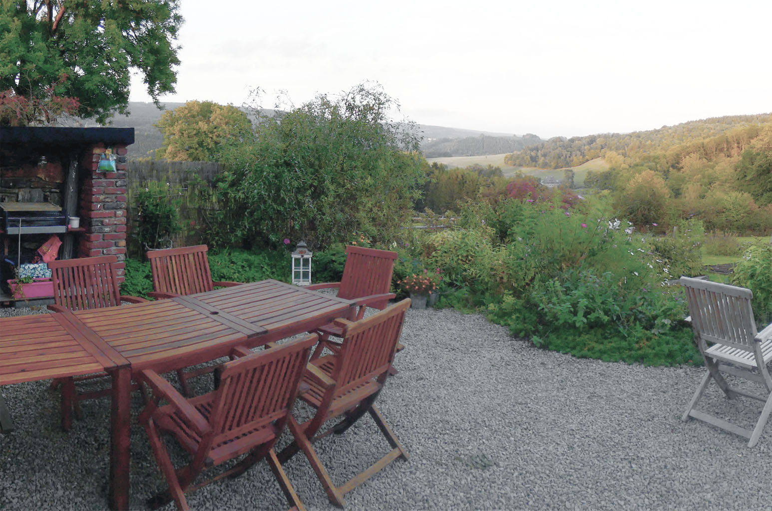 Terrasse meublée avec barbecue, salon de jardin et balancoires